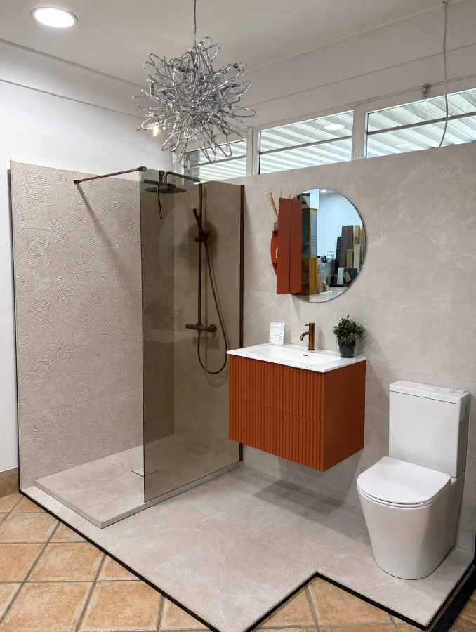 Baño con mueble Biba terracota, mampara de cristal ahumado y revestimiento Masaya Art Beige